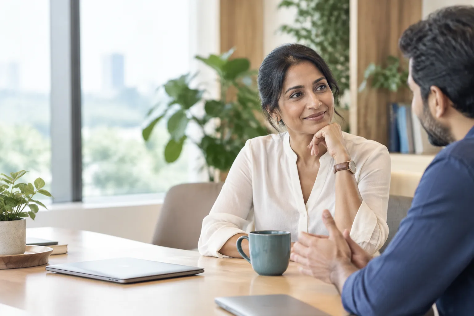 Two colleagues in a calm, friendly one-to-one conversation at work